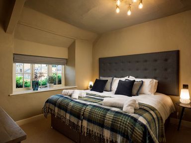 A bedroom with a bed and window at Whalesborough Farmhouse Spa in Marhamchurch