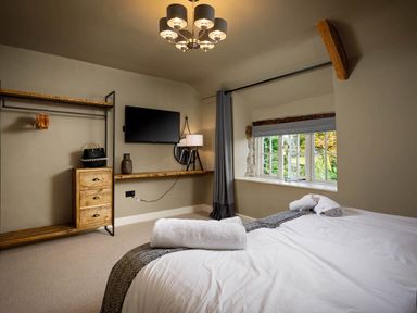 A bedroom with a bed and television at Whalesborough Farmhouse Spa in Marhamchurch