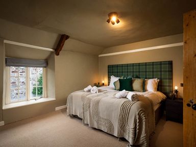 A bedroom with a bed and window at Whalesborough Farmhouse Spa Marhamchurch