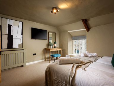 A bedroom with a bed and a television at Whalesborough Farmhouse Spa in Marhamchurch