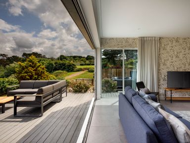 A living room with sofas and a television at Whalesborough Cottage Spa in Marhamchurch