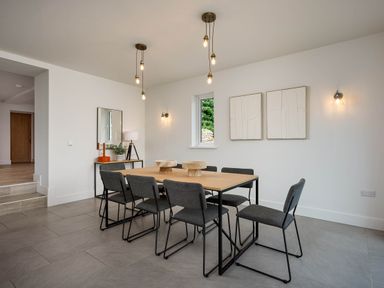 A dining room with a table and chairs at Whalesborough Cottage Spa Marhamchurch