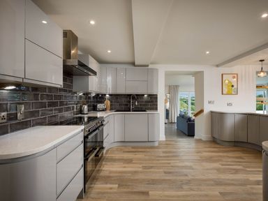 A kitchen with gray cabinets and appliances at Whalesborough Cottage Spa in Marhamchurch