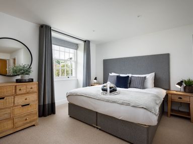 A bedroom with a bed and nightstand at Whalesborough Cottage Spa in Marhamchurch