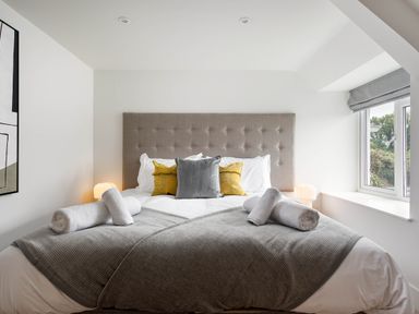 A bedroom with a bed and artwork at Whalesborough Cottage Spa in Marhamchurch