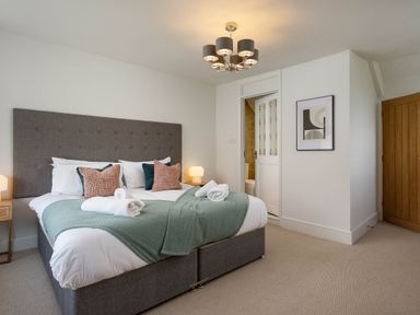 A bedroom with a bed and lamp at Whalesborough Cottage Spa in Marhamchurch