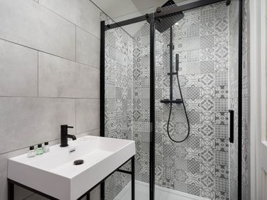 A bathroom with shower and sink at Whalesborough Cottage Spa in Marhamchurch