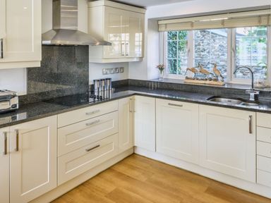 A kitchen with a sink and cabinets at Calf House Spa Marhamchurch