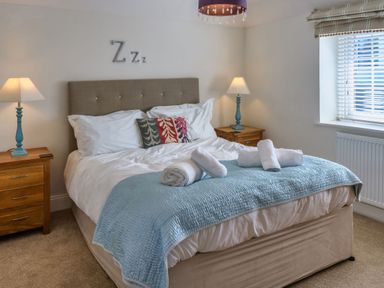 A bedroom with a bed and nightstands at Calf House Spa Marhamchurch