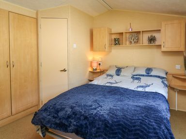 A bedroom with a bed and wardrobe at Caravan 2 at Blackmoor Farm near tenby
