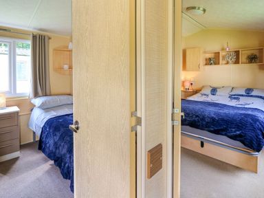 A bedroom with two beds and a window at Caravan 2 at Blackmoor Farm near tenby Narberth