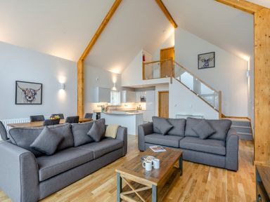 A living room with a sofa and dining area at Tranquillity 4 in Carnforth