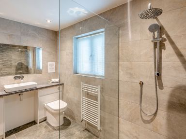 A bathroom with a shower, toilet, and sink at Tranquillity 4 in Carnforth
