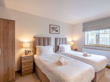 A bedroom with twin beds and a nightstand at Tranquillity 4 (Pet) in Carnforth