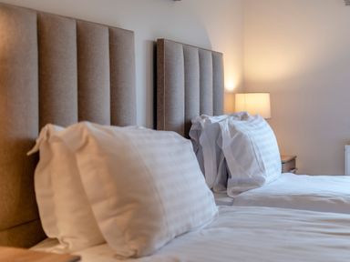 A bedroom with two beds and a bedside lamp at Tranquillity 4 (Pet) in Carnforth