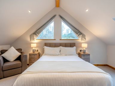 A bedroom with a bed, armchair and windows at Tranquillity 4 (Pet) in Carnforth
