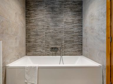 A bathtub with tiles on the wall at Tranquillity 4 (Pet) Carnforth