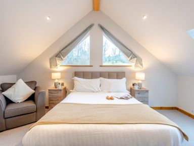 A bedroom with a bed and armchair at Tranquillity 4 (Pet) in Carnforth