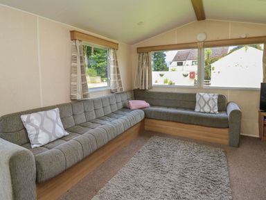 A living room with a sofa and windows at Caravan 3 at Blackmoor Farm near tenby