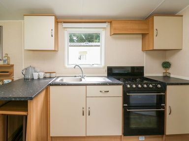 A kitchen with a sink and oven at Caravan 3 at Blackmoor Farm near tenby