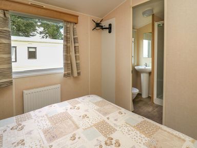 A bedroom with a bed and an adjoining bathroom at Caravan 3 at Blackmoor Farm near tenby