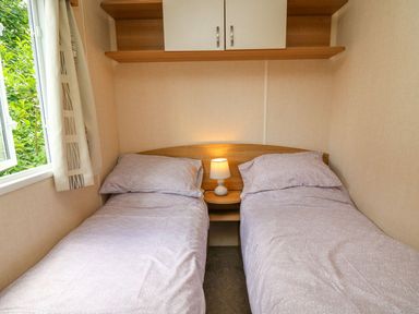 A bedroom with two beds and a lamp at Caravan 3 at Blackmoor Farm near tenby