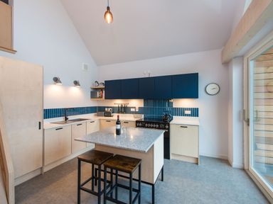 A kitchen with a central island and stools at The Telfer in North Berwick