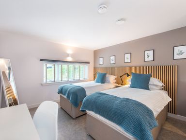 A bedroom with twin beds and a desk at The Telfer in North Berwick