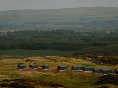 Cabins and wind turbines in a field at The Telfer North Berwick