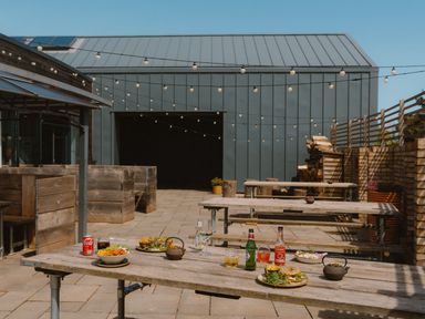 An outdoor dining area with wooden tables and dishes at The Telfer in North Berwick