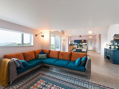 A living room with a sofa and dining area at The Irvine in North Berwick