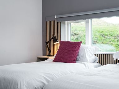 A bedroom with two beds and a bedside lamp at The Irvine in North Berwick