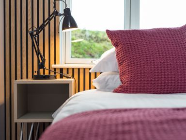 A bedroom with a bed and lamp on a nightstand at The Irvine in North Berwick