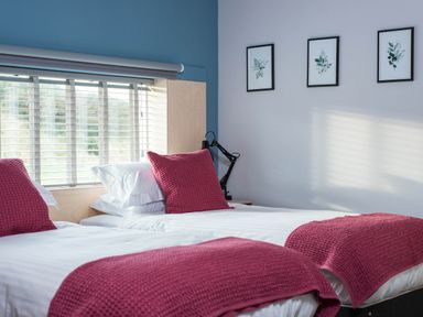 A bedroom with two beds, a window and wall art at The Laidlaw Spa in North Berwick