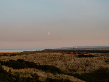A view of the ocean and moon over grassland at The Laidlaw Spa in North Berwick