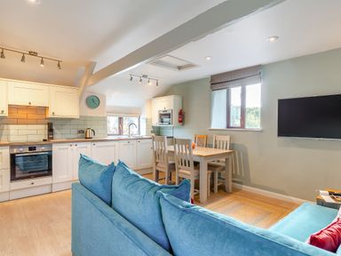 A kitchen with a sofa and dining area at Crabtree Cottage in Bude