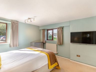 A bedroom with a bed and television at Crabtree Cottage in Bude