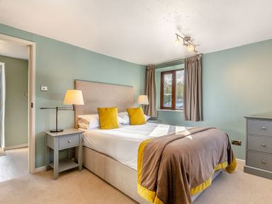 A bedroom with a bed and bedside table at Crabtree Cottage in Bude