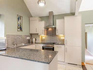 A kitchen with cabinets and appliances at Godolphin Stable in Bude