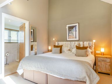A bedroom with a double bed and connected bathroom at Godolphin Stable, Bude