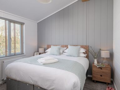 A bedroom with a double bed and nightstand at Kynance Spa (Pet) in Bude