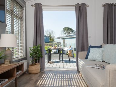 A living room with a sofa and a table at Kynance Spa in Bude