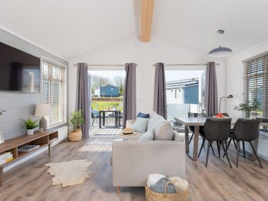 A living room with a sofa and dining area at Kynance Spa in Bude