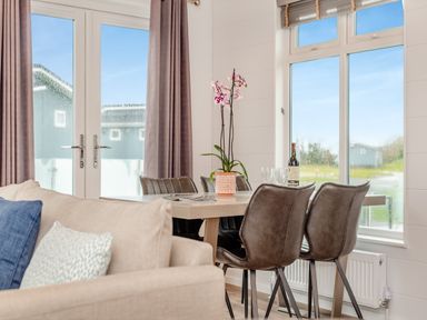 A living room with a dining table and chairs at Kynance Spa in Bude