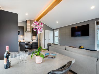 A living room with a kitchen area and dining table at Kynance Spa in Bude
