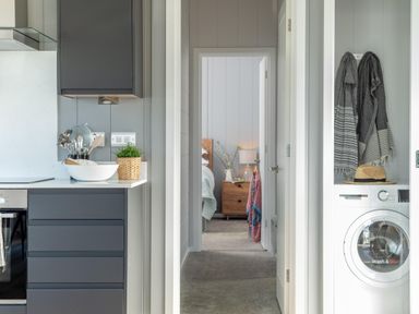 A kitchen with cabinets and washing machine at Kynance Spa in Bude