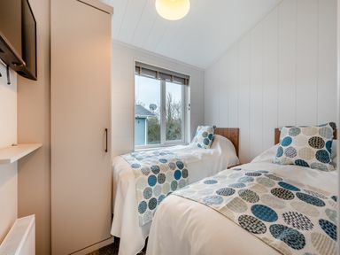 A bedroom with two beds and a television at Kynance Spa in Bude