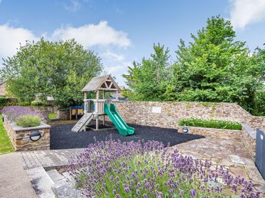 An outdoor playground with a slide and climbing frame at Kynance Spa Bude