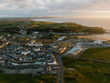An aerial view of a coastal town with buildings and beach area at Kynance Spa in Bude