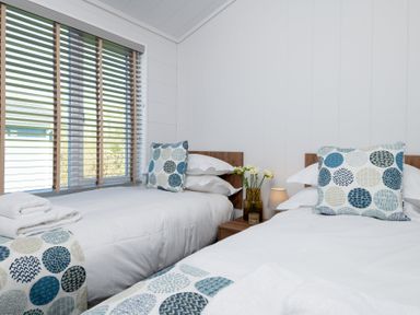 A bedroom with two beds and a window at Kynance (Pet) Bude